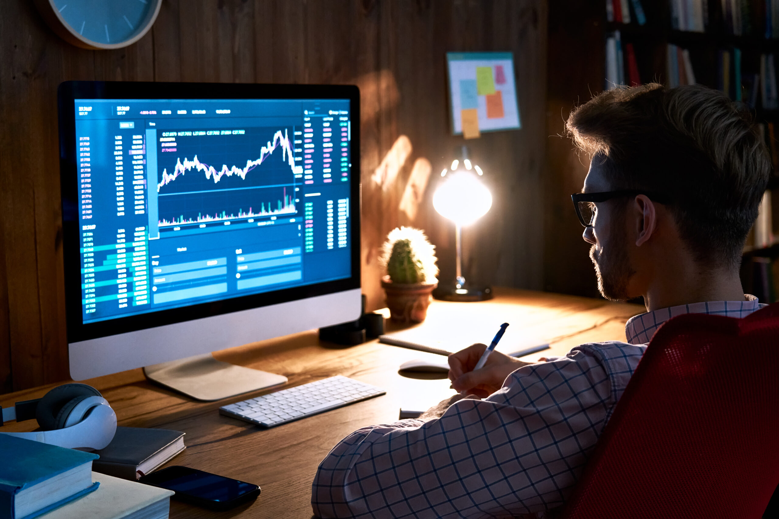 Stock market analyst looking at computer trading online analyzing data.